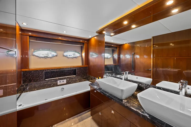 Oasis Yacht Photos Pics Luxurious bathroom in 2010 Princess 95 Motor Yacht with dual sinks and elegant wood finishes.