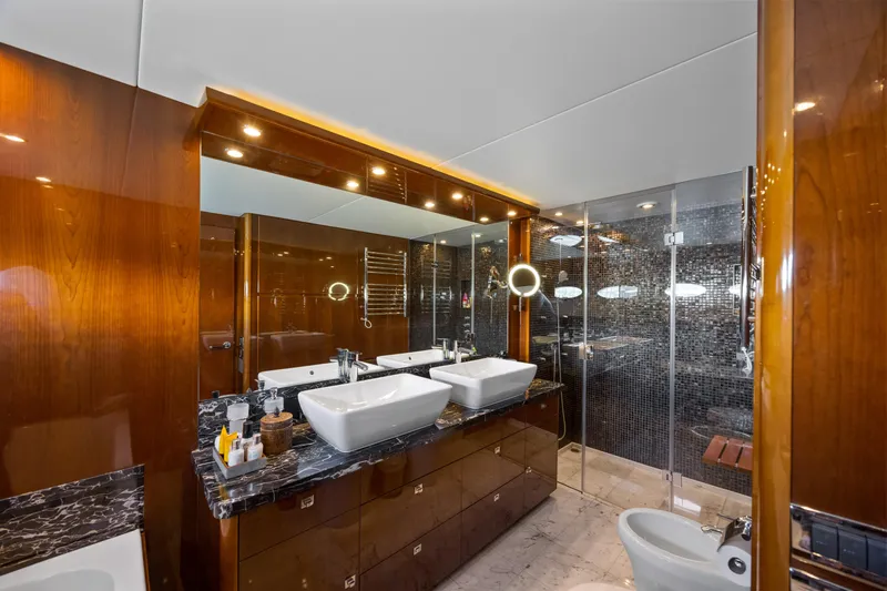 Oasis Yacht Photos Pics Luxurious bathroom in 2010 Princess 95 Motor Yacht with dual sinks and elegant wood finishes.