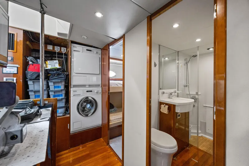 Oasis Yacht Photos Pics Laundry and bathroom area on 2010 Princess 95 Motor Yacht, featuring washer, dryer, and shower.