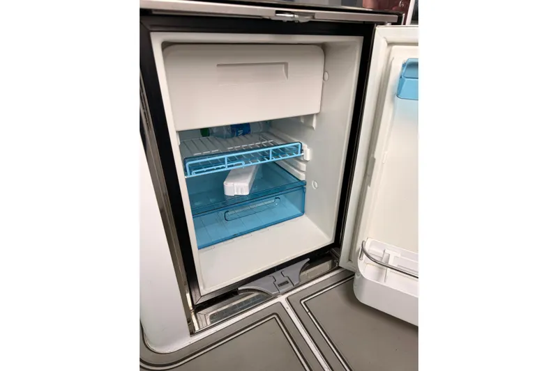  Yacht Photos Pics Open refrigerator inside 2021 Axopar 37 XC Cross Cabin boat, showing shelves and storage.