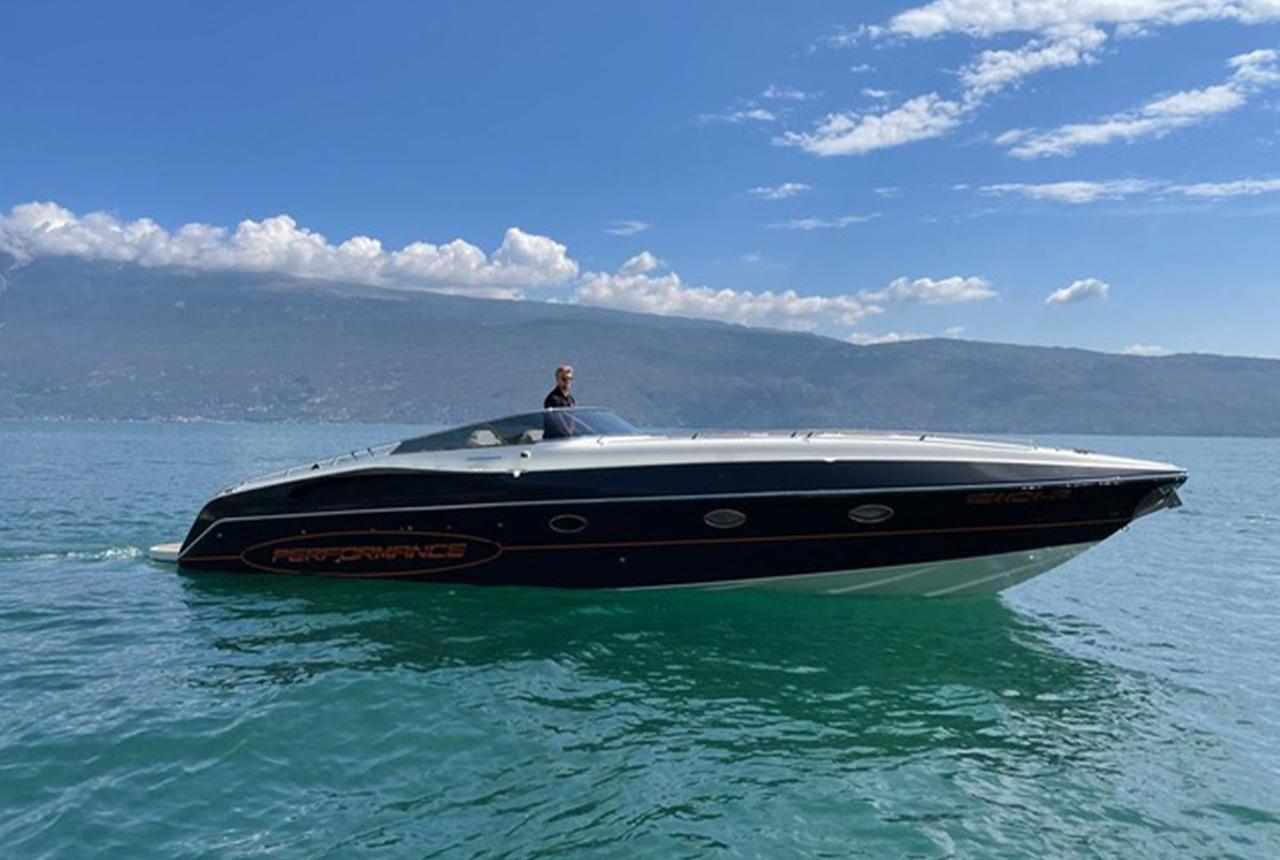 2022 Performance 1201 speedboat cruising on a serene lake under a clear blue sky.