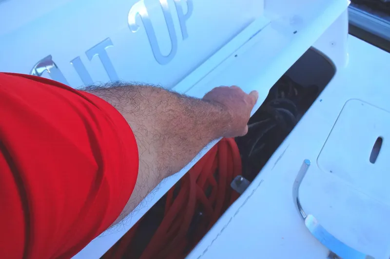 Lit Up Yacht Photos Pics Man opening storage compartment on 2007 Meridian 459 boat deck.