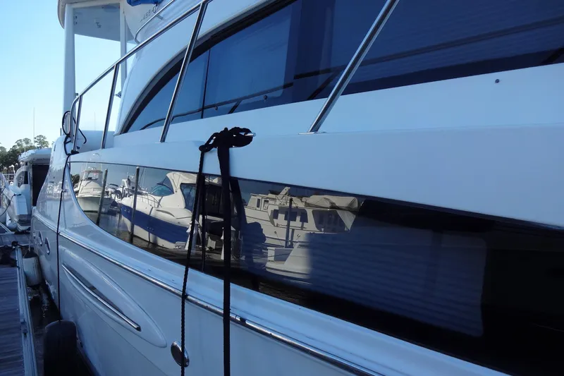 Lit Up Yacht Photos Pics 2007 Meridian 459 yacht docked, reflecting nearby boats on its sleek exterior.