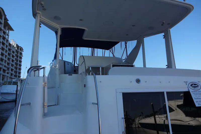 Lit Up Yacht Photos Pics 2007 Meridian 459 yacht with upper deck view, docked near waterfront buildings.