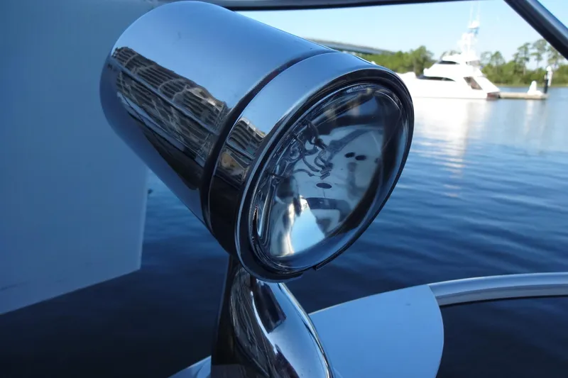 Lit Up Yacht Photos Pics Close-up of a 2007 Meridian 459 yacht spotlight with water and boats in the background.