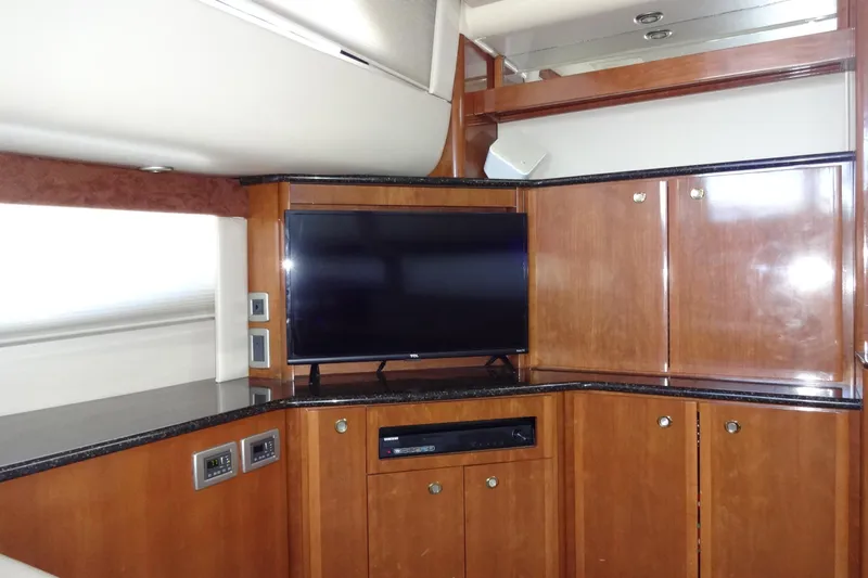 Lit Up Yacht Photos Pics Interior of 2007 Meridian 459 yacht with wooden cabinets and a flat-screen TV.