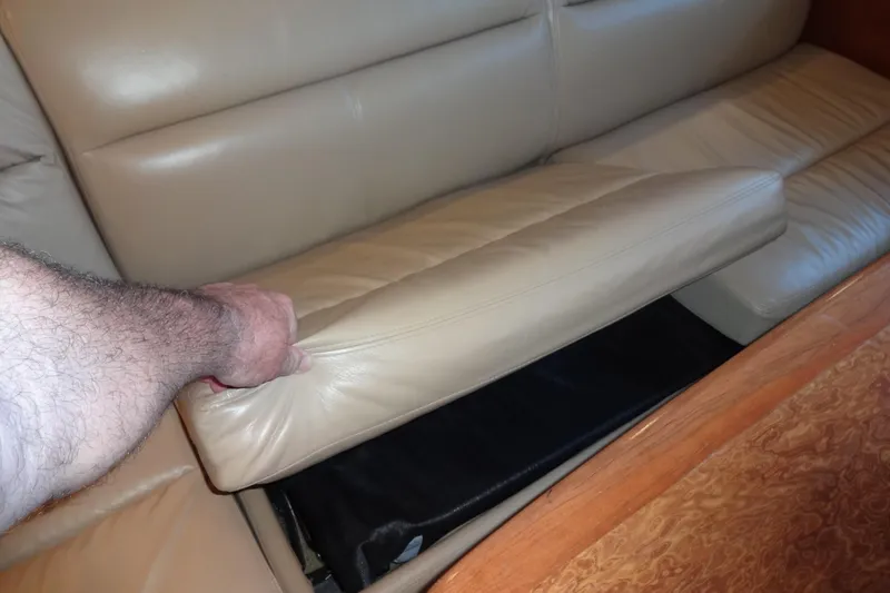 Lit Up Yacht Photos Pics Hand lifting cushion on 2007 Meridian 459 yacht's beige leather sofa.