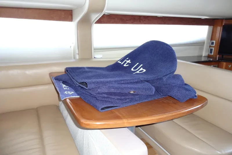 Lit Up Yacht Photos Pics Luxurious interior of 2007 Meridian 459 yacht with blue fender covers on wooden dinette table.