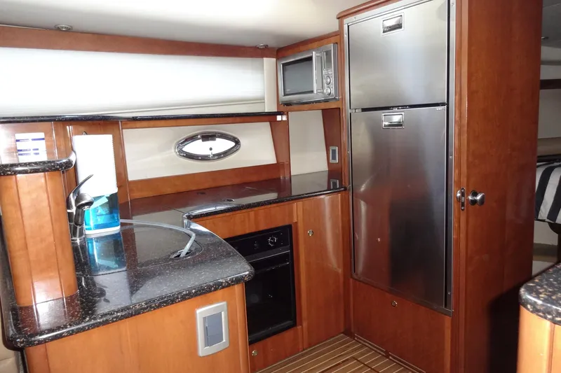 Lit Up Yacht Photos Pics Luxurious 2007 Meridian 459 yacht kitchen with wood cabinetry and stainless steel appliances.