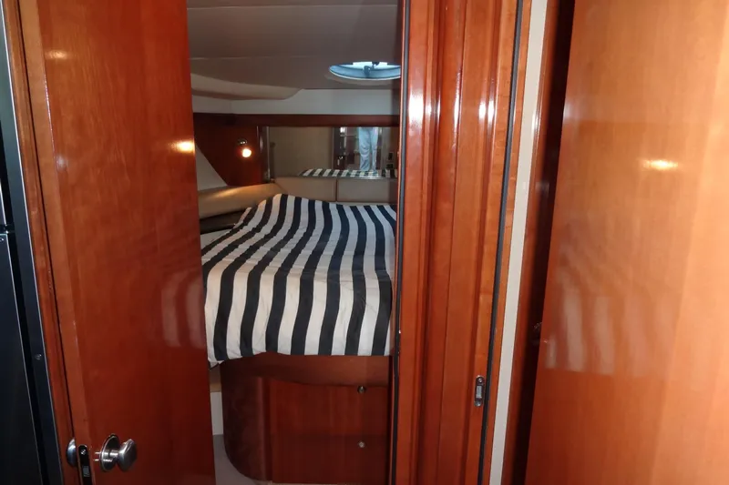 Lit Up Yacht Photos Pics Interior cabin of 2007 Meridian 459 yacht with striped bedding and wooden finishes.