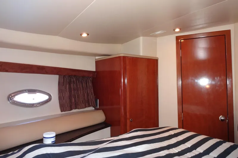 Lit Up Yacht Photos Pics Luxurious cabin interior of 2007 Meridian 459 yacht with wood finishes and striped bedding.