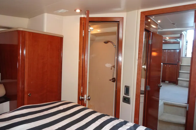 Lit Up Yacht Photos Pics Interior of 2007 Meridian 459 yacht with wood finishes and striped bedding.