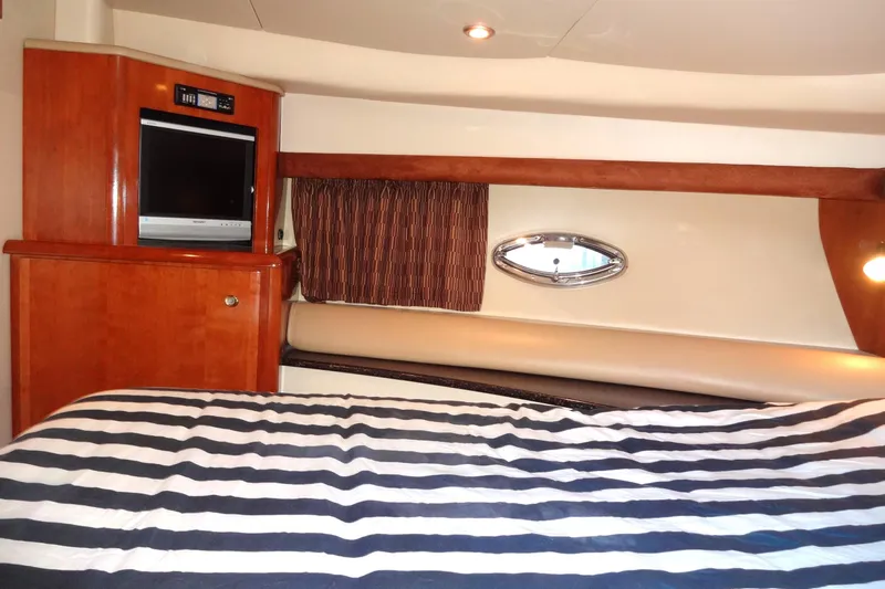 Lit Up Yacht Photos Pics Luxurious 2007 Meridian 459 yacht interior with striped bedding and wood cabinetry.