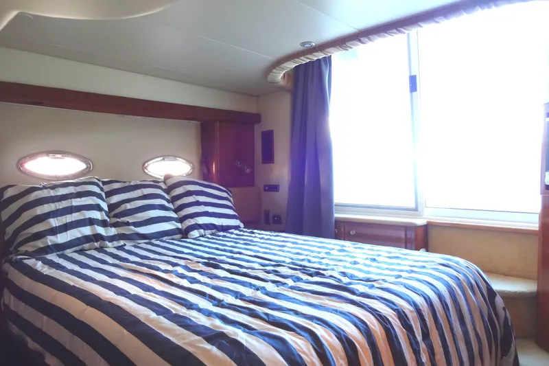 Lit Up Yacht Photos Pics Luxurious bedroom in 2007 Meridian 459 yacht with striped bedding and porthole windows.