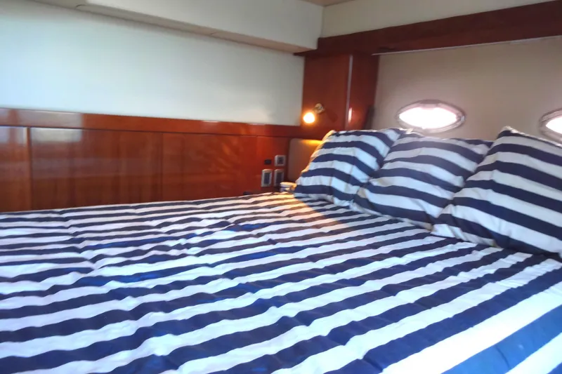 Lit Up Yacht Photos Pics Luxurious 2007 Meridian 459 yacht bedroom with striped bedding and wooden accents.