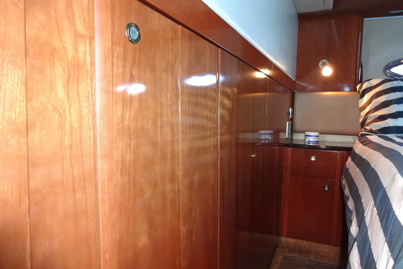 Lit Up Yacht Photos Pics Luxurious wooden interior of a 2007 Meridian 459 yacht cabin with striped bedding.