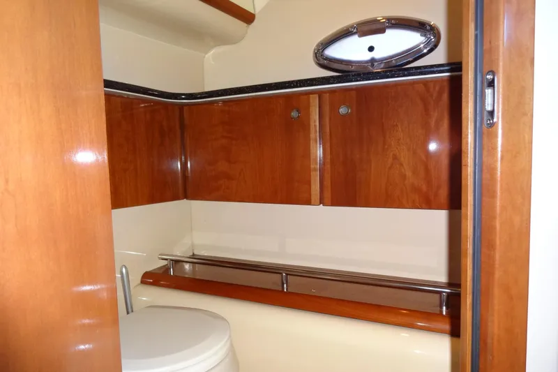 Lit Up Yacht Photos Pics 2007 Meridian 459 yacht bathroom with wooden cabinets and porthole window.