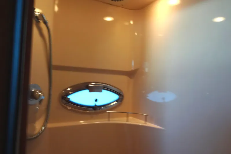 Lit Up Yacht Photos Pics Shower area in 2007 Meridian 459 yacht with oval window and chrome fixtures.