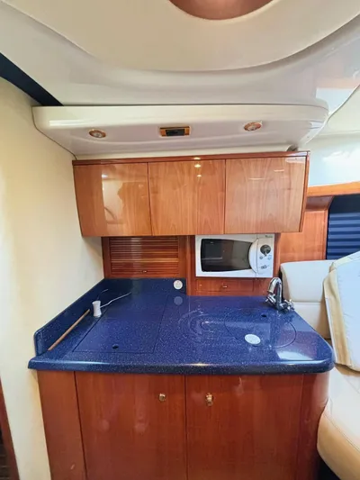  Yacht Photos Pics 2009 Cranchi Endurance 41 yacht kitchen with blue countertop and wooden cabinets.