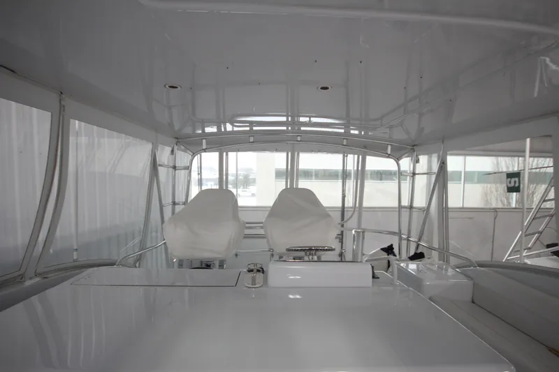 Rollwind Yacht Photos Pics Interior view of 2001 Hatteras 55 Convertible yacht's helm area with covered seats.