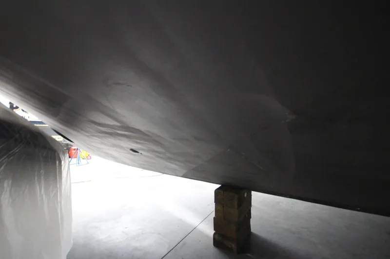 Rollwind Yacht Photos Pics Bottom view of 2001 Hatteras 55 Convertible yacht on blocks in a workshop.