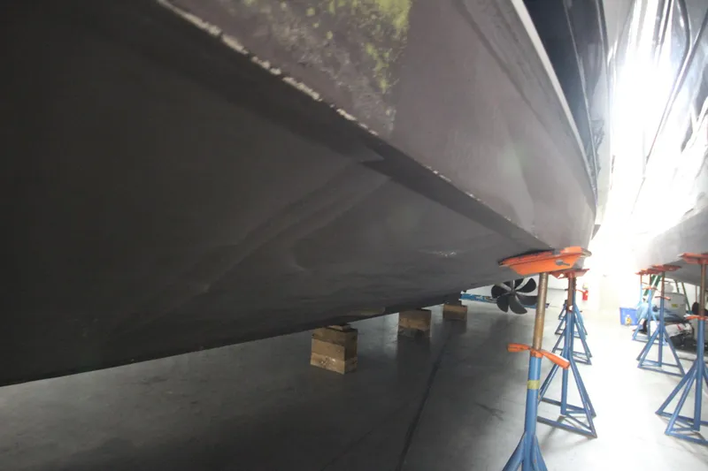 Rollwind Yacht Photos Pics Hatteras 55 Convertible 2001 yacht hull on stands in a maintenance facility.