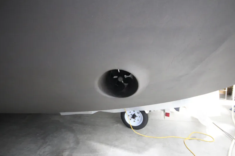 Rollwind Yacht Photos Pics Hatteras 55 Convertible 2001 boat hull with thruster, in a garage setting.