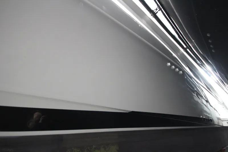 Rollwind Yacht Photos Pics Close-up of 2001 Hatteras 55 Convertible yacht hull, showcasing sleek design and reflective surface.