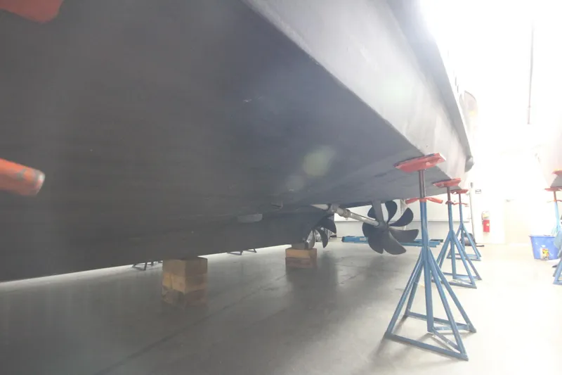 Rollwind Yacht Photos Pics Hatteras 55 Convertible 2001 yacht on stands, showcasing propellers and hull in a workshop.