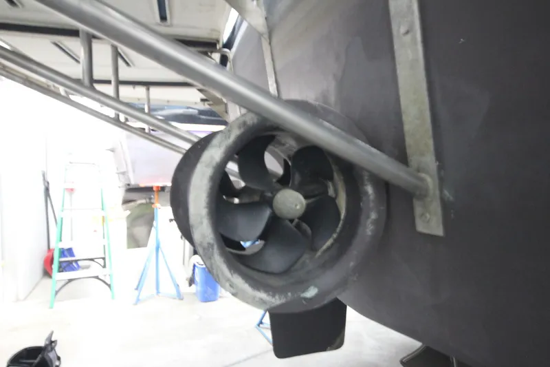 Rollwind Yacht Photos Pics Close-up of a 2001 Hatteras 55 Convertible boat's propeller in a garage setting.