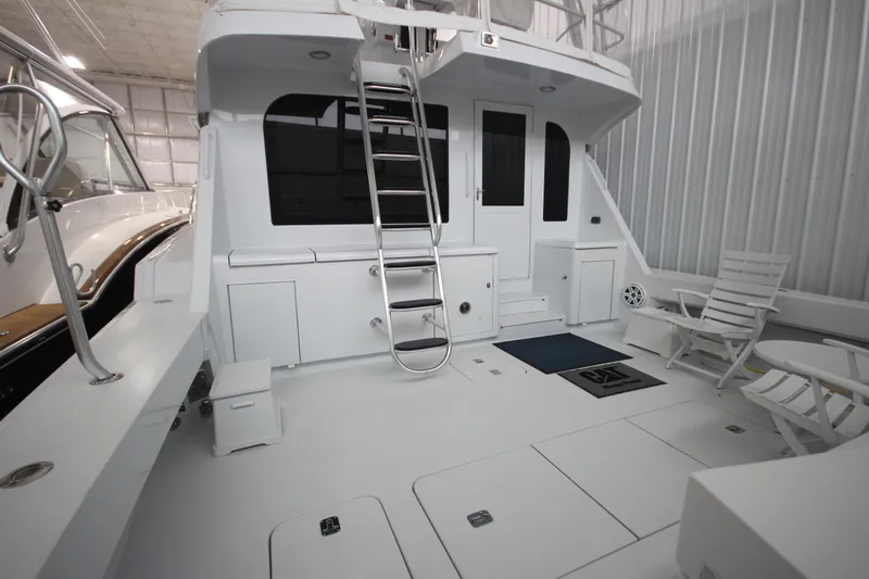 Rollwind Yacht Photos Pics 2001 Hatteras 55 Convertible yacht deck with seating and ladder in a marina.