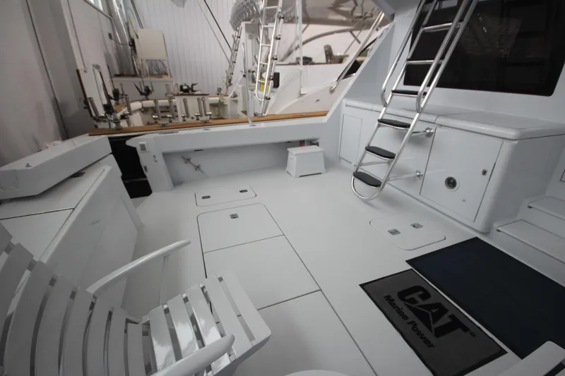 Rollwind Yacht Photos Pics 2001 Hatteras 55 Convertible yacht deck with seating and ladder in a marina setting.