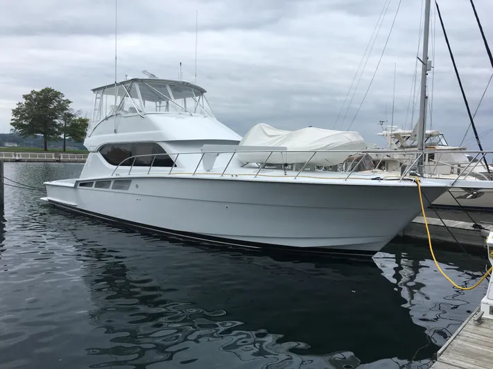 Rollwind Yacht Photos Pics 2001 Hatteras 55 Convertible yacht docked in marina, overcast sky.