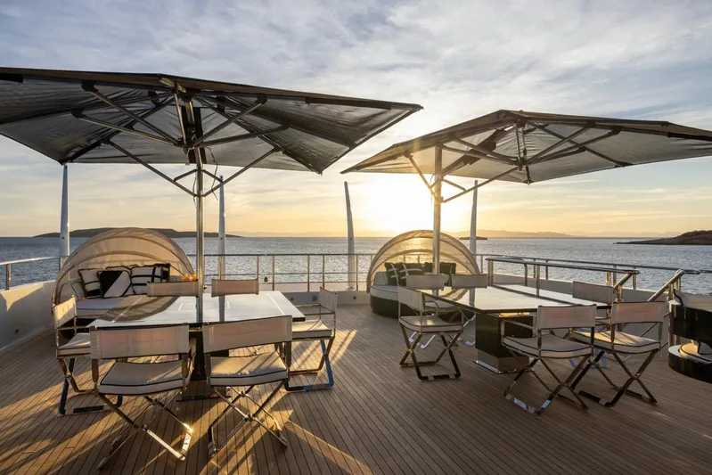 Alfa G Yacht Photos Pics Luxurious Oceanco 60-meter yacht deck with seating, umbrellas, and sunset view, built in 2004.