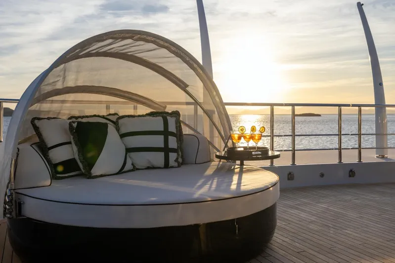 Alfa G Yacht Photos Pics Luxurious Oceanco yacht deck with sunbed, pillows, and drinks at sunset, 2004 model.