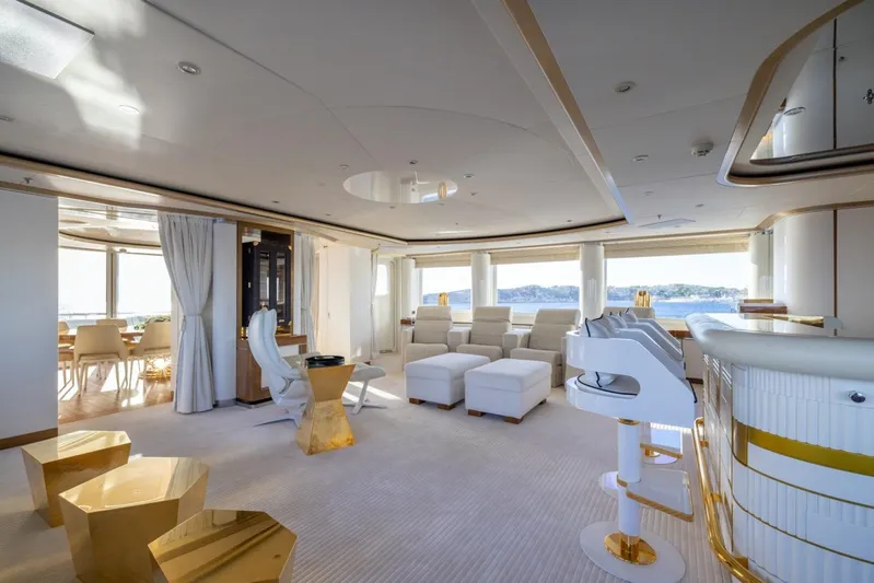 Alfa G Yacht Photos Pics Luxurious yacht interior with modern white and gold decor, featuring plush seating and panoramic windows.