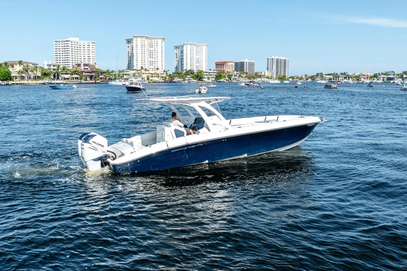  Yacht Photos Pics 2020 Midnight Express 34 Open boat cruising on a sunny day with city skyline in the background.