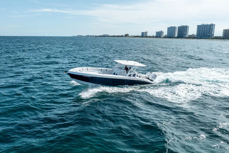  Yacht Photos Pics 2020 Midnight Express 34 Open boat cruising on the ocean near a city skyline.