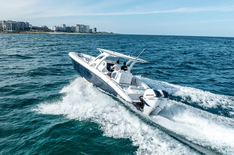  Yacht Photos Pics 2020 Midnight Express 34 Open boat cruising on the ocean near a coastal city.