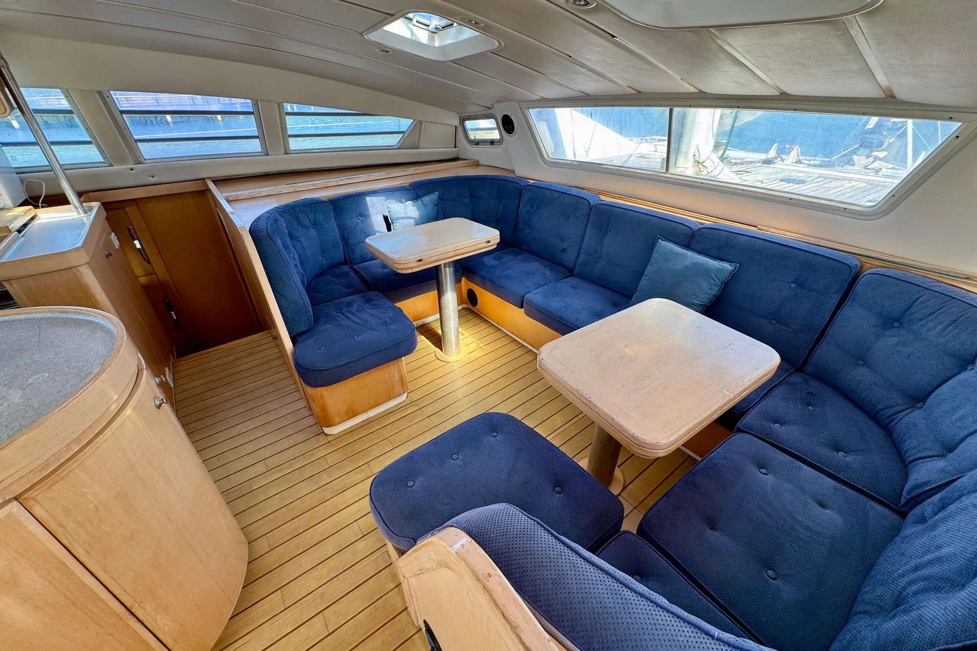 Luxurious 1992 Wauquiez Kronos yacht interior with blue seating and wooden accents.