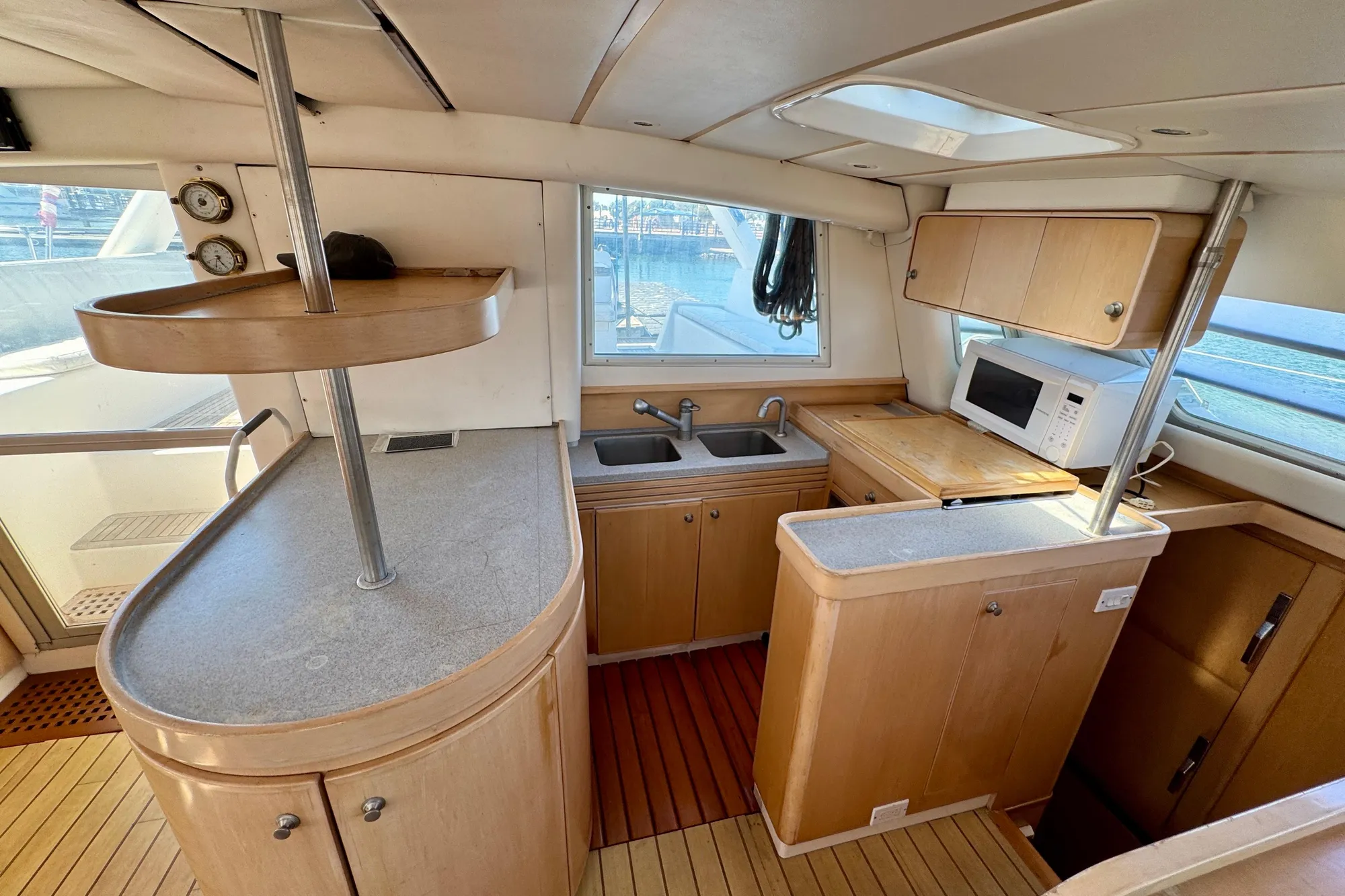Interior of 1992 Wauquiez Kronos yacht kitchen with wooden cabinetry and modern appliances.