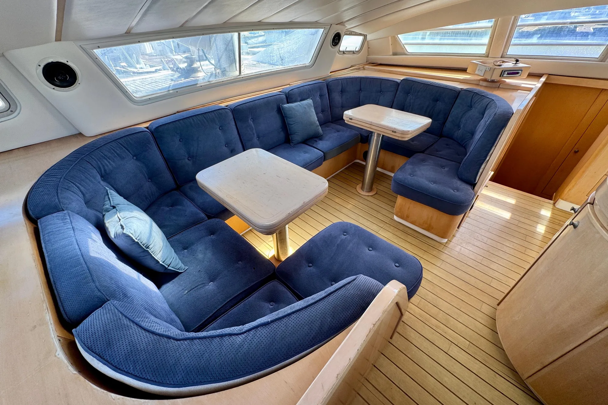 Luxurious 1992 Wauquiez Kronos yacht interior with blue seating and wooden flooring.
