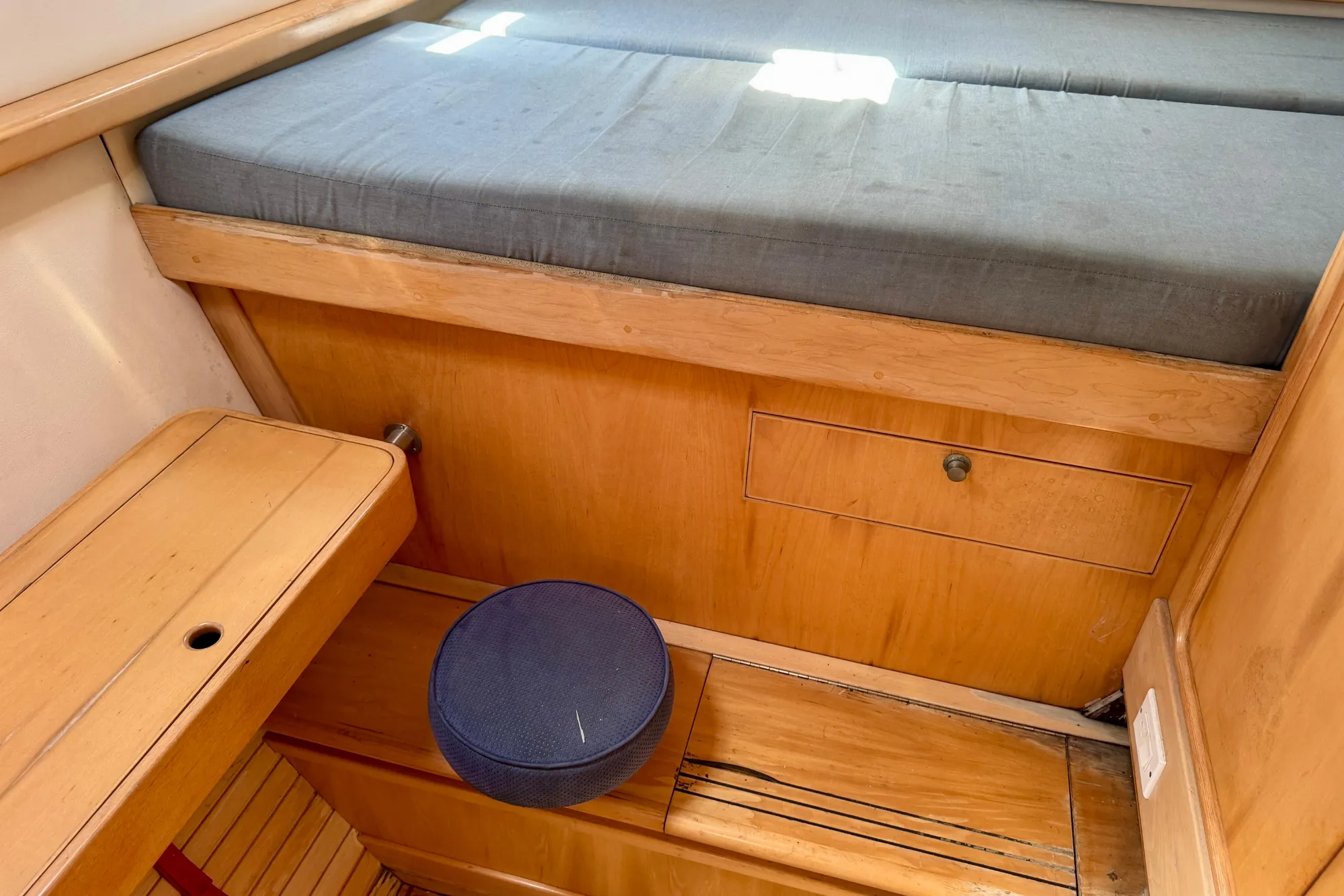 Interior of 1992 Wauquiez Kronos sailboat with wooden cabinetry and cushioned seating.