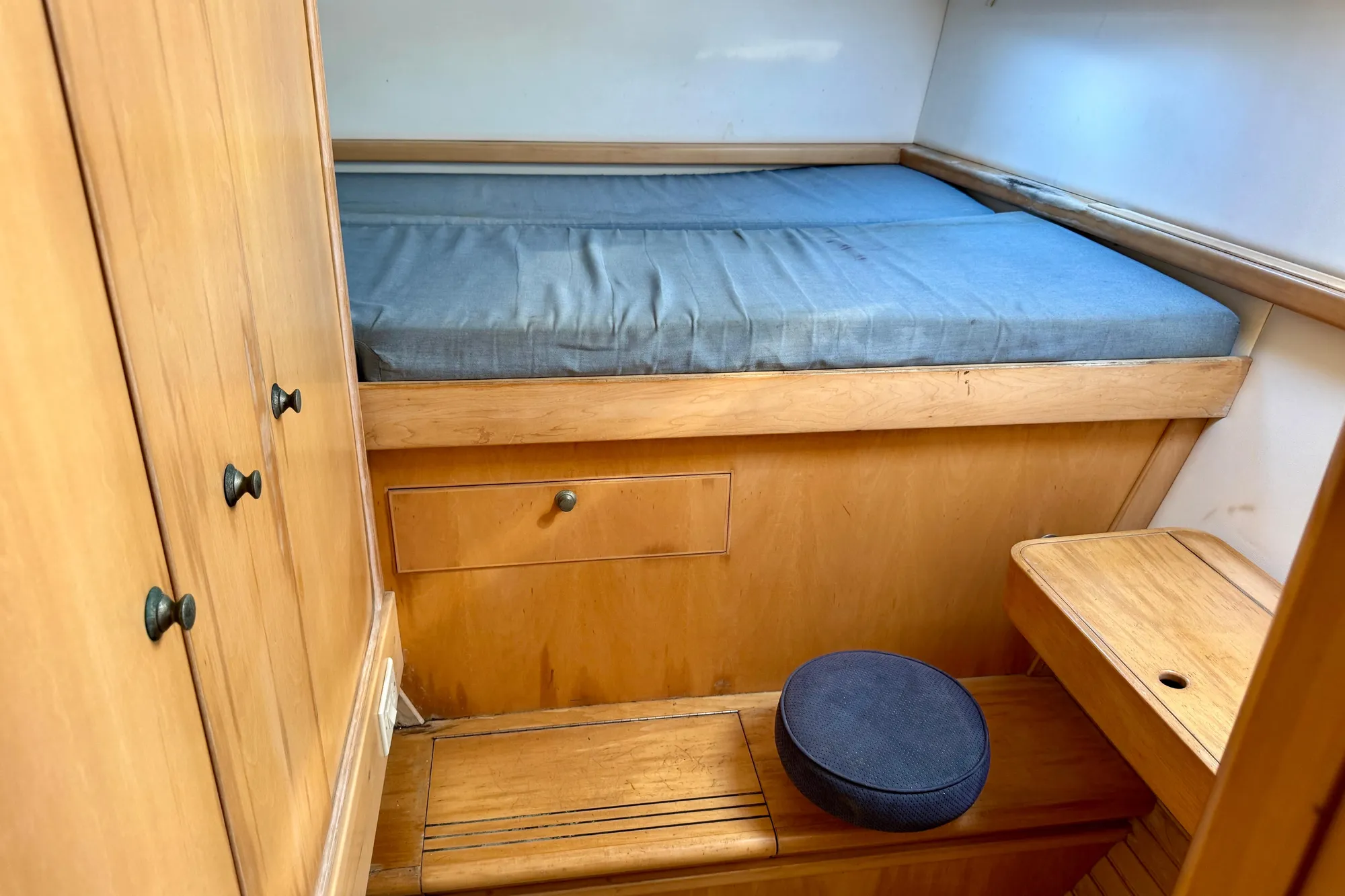 Cozy cabin interior of 1992 Wauquiez Kronos sailboat with wooden furnishings and blue mattress.