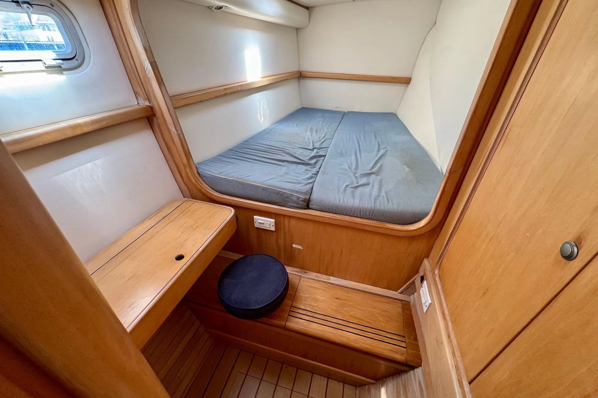 Cozy cabin interior of 1992 Wauquiez Kronos sailboat with wooden furnishings and bed.