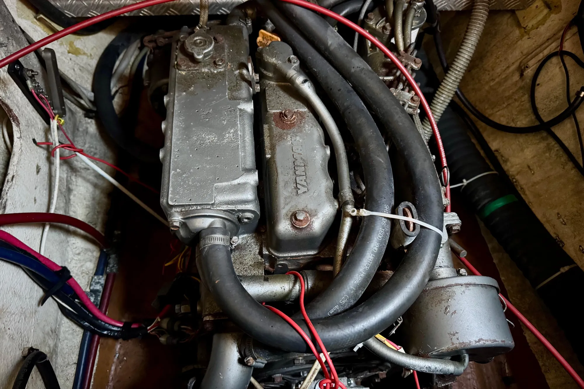 Engine compartment of a 1992 Wauquiez Kronos sailboat, featuring hoses and wiring.