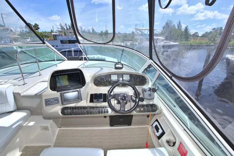 High Hopes Yacht Photos Pics 2004 Cruisers Yachts 370 Express helm with navigation equipment and scenic marina view.