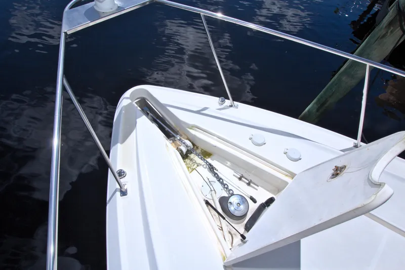 High Hopes Yacht Photos Pics 2004 Cruisers Yachts 370 Express bow with anchor and railing, docked on calm water.