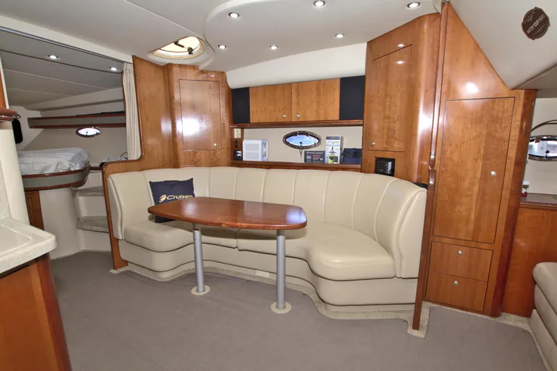High Hopes Yacht Photos Pics 2004 Cruisers Yachts 370 Express interior with beige seating and wooden cabinetry.
