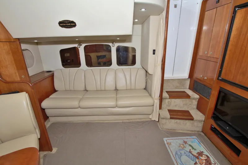 High Hopes Yacht Photos Pics Interior of 2004 Cruisers Yachts 370 Express, featuring beige leather sofa and wooden cabinetry.